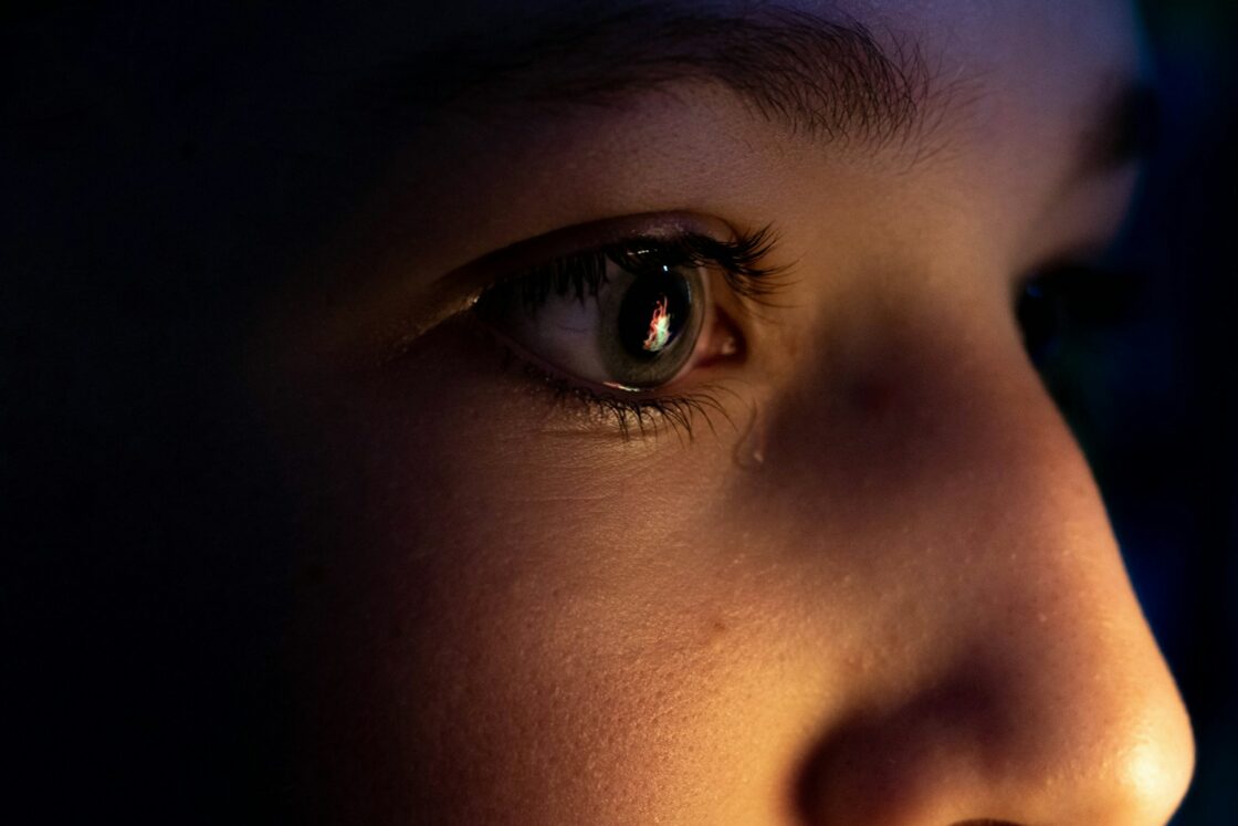 a close up of a child's face with a dark background